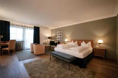a hotel room with a bed and a living room at Hotel Hanswirt in Rablà