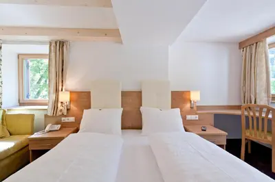 a bedroom with two beds and a couch at Gasthof Zur Sonne in Cardano