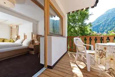 a bedroom with a bed and a table with a chair at Gasthof Zur Sonne in Cardano