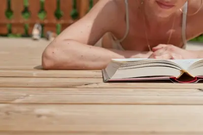 a woman laying on the floor reading a book at Gasthof Zur Sonne in Cardano