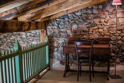 an old piano in a room with a stone wall at rössl bianco b&b&b in Merano