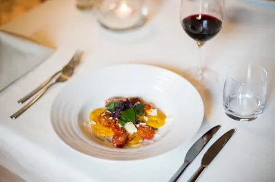 a plate of food on a table with a glass of wine at rössl bianco b&b&b in Merano