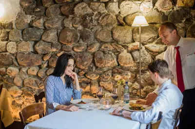 a group of people sitting around a table eating food at rössl bianco b&b&b in Merano