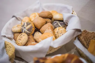 a basket of different types of bread and pastries at rössl bianco b&b&b in Merano