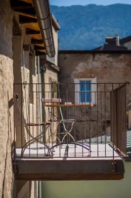 a balcony with a table and chairs on it at rössl bianco b&b&b in Merano