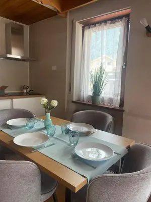a dining room table with chairs and a window at Ciasa Cianins in San Vigilio Di Marebbe