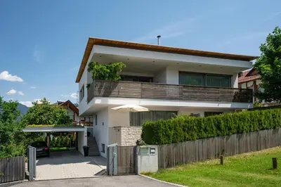 a white house with a fence in front of it at Apartment Oberlechner in Riscone