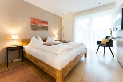 a bedroom with a large bed with white sheets at Apartment Oberlechner in Riscone