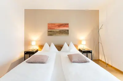a large white bed with two pillows on it at Apartment Oberlechner in Riscone
