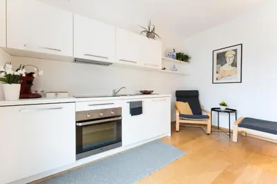 a kitchen with white cabinets and a table and chairs at Apartment Oberlechner in Riscone