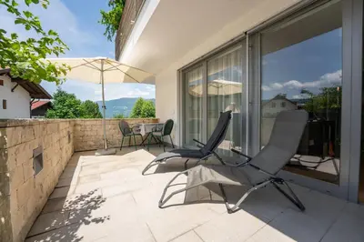 a patio with two chairs and an umbrella at Apartment Oberlechner in Riscone