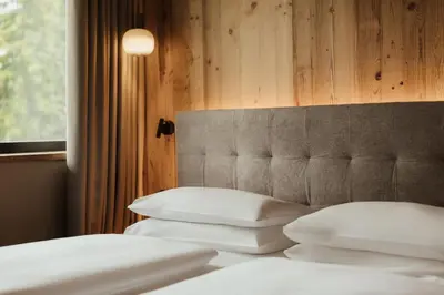 a bedroom with two beds with white pillows at Waldrast - Forestside Living in Siusi