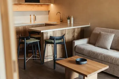 a small kitchen with a bar and a couch at Waldrast - Forestside Living in Siusi