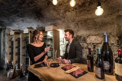 a man and woman sitting at a table with wine glasses at Waldrast - Forestside Living in Siusi