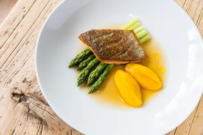 a plate of food with fish and vegetables on a table at Hotel Heubad in Fiè