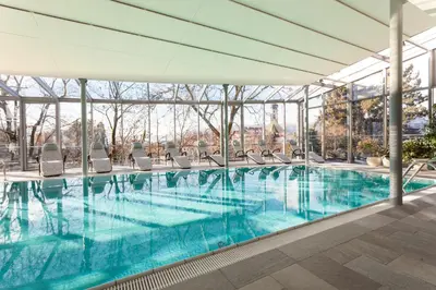 a large swimming pool with chairs in a building at Hotel Heubad in Fiè