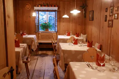 a restaurant with three tables with white table cloth at Hotel Heubad in Fiè