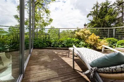 a balcony with a chair on a wooden deck at Hotel Heubad in Fiè