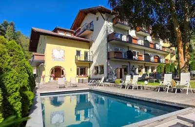 a hotel with a swimming pool in front of a building at Solaia Hotel & Guesthouse in Castelrotto