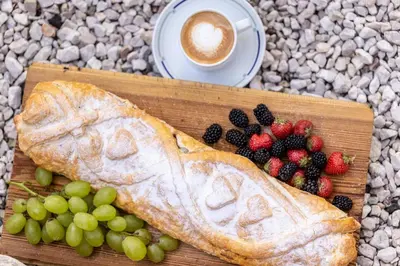 a loaf of bread with fruit and a cup of coffee at Solaia Hotel & Guesthouse in Castelrotto
