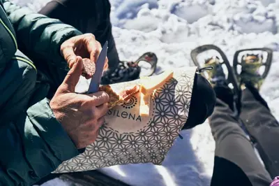 a person holding a sandwich in a bag in the snow at SILENA, your soulful hotel - adults only in Valles