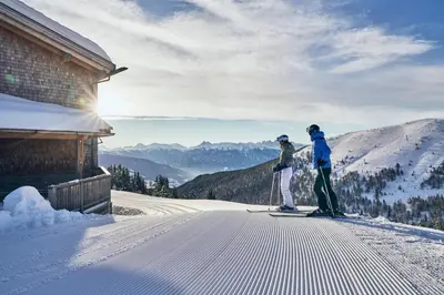 two people on skis in the snow next to a building at SILENA, your soulful hotel - adults only in Valles