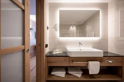 a bathroom with a sink and a mirror at Small & Beautiful Hotel Gnaid in Tirolo