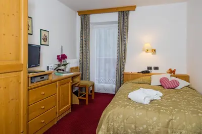 a hotel room with a bed and a television at Hotel Bellavista in Canazei