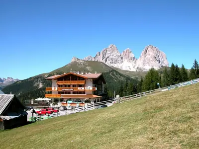 a large building in front of a mountain at Hotel Bellavista in Canazei