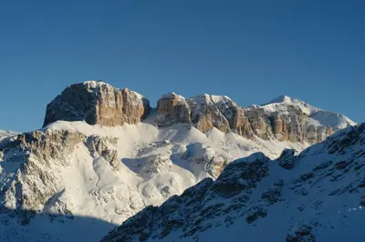 a mountain covered in snow with a blue sky at Hotel Bellavista in Canazei