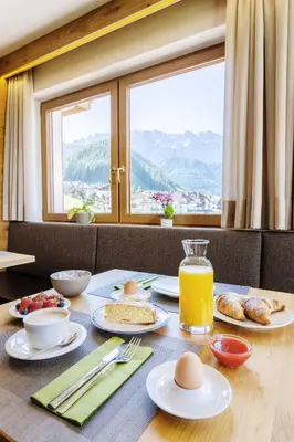 a table with food and eggs on it with a window at Garni Charlotte in Selva di Val Gardena