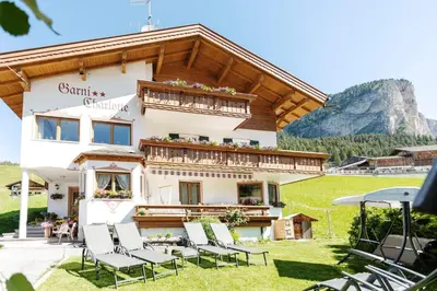 a building with chairs in front of it at Garni Charlotte in Selva di Val Gardena