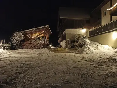 a snow covered street at night with a building at Natur Apartments Riesen in San Lorenzo di Sebato