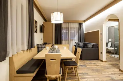 a living room with a table and a couch at San Martino Mountain Residence in San Martino di Castrozza