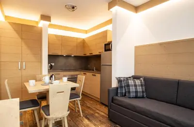 a living room with a couch and a table at San Martino Mountain Residence in San Martino di Castrozza