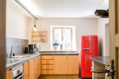 a kitchen with a red refrigerator and wooden cabinets at Chalet Hafling Zoila in Avelengo