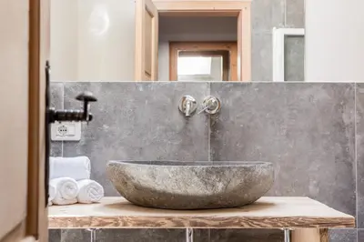 a bathroom with a large stone sink on a counter at Chalet Hafling Zoila in Avelengo