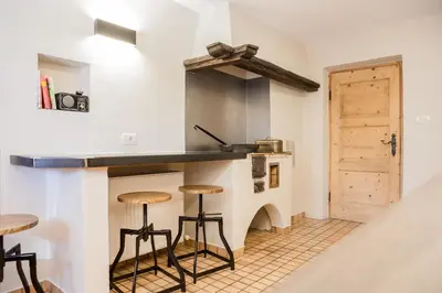 a kitchen with a counter and stools in a room at Chalet Hafling Zoila in Avelengo