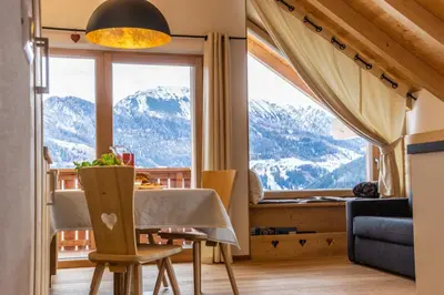 a dining room with a table and a large window at agriturismo Lüch Picedac in La Valle