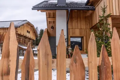 a wooden fence in front of a house at agriturismo Lüch Picedac in La Valle