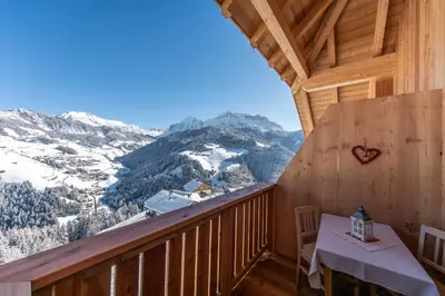 a balcony with a table and a view of a mountain at agriturismo Lüch Picedac in La Valle