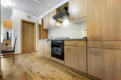 a kitchen with wooden cabinets and a stove at Holzerhof Lothen , Campolino in San Lorenzo di Sebato