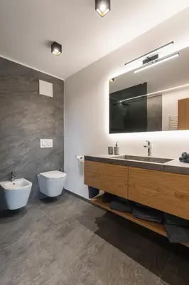 a bathroom with a sink and a toilet and a mirror at Beim Lackl in Avelengo