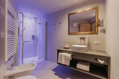 a purple bathroom with a sink and a mirror at Hotel Castel Oswald von Wolkenstein in Castelrotto