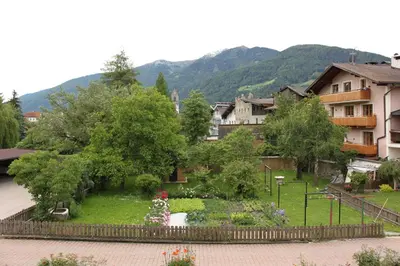 a garden with flowers and trees in a town at Residence die Färbe in Vipiteno