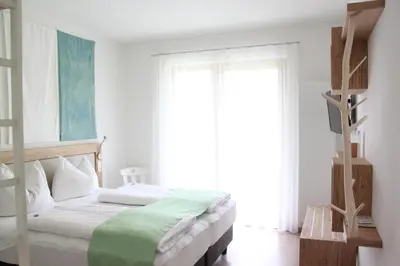 a bedroom with a bed and a large window at Residence die Färbe in Vipiteno