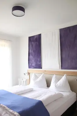 two beds with white and blue sheets in a bedroom at Residence die Färbe in Vipiteno
