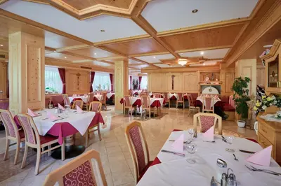 a restaurant with tables and chairs in a room at Alpenhotel Schönwald Superior in Valles