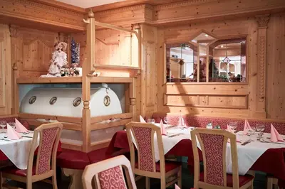 a dining room with tables and chairs and a tub at Alpenhotel Schönwald Superior in Valles