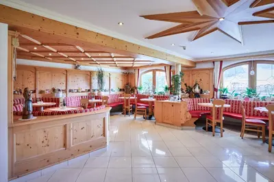 a restaurant with tables and chairs in a room at Alpenhotel Schönwald Superior in Valles